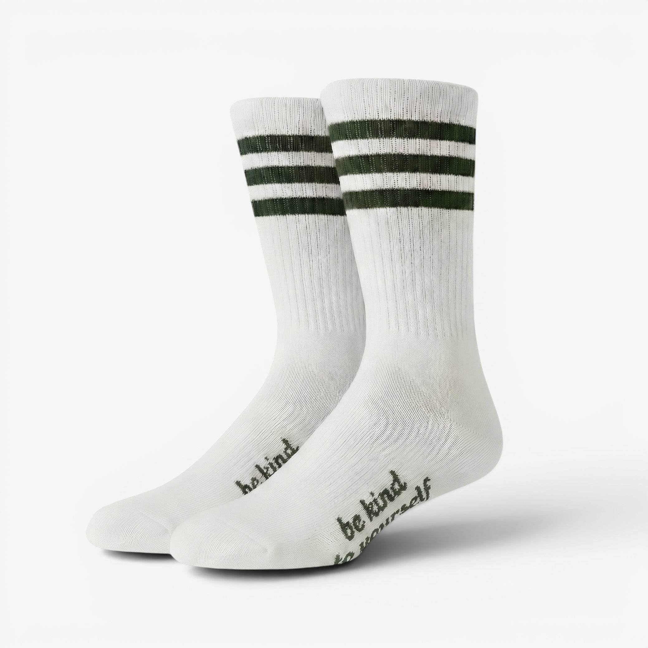 White socks with green stripes and 'be kind' text on a white background
