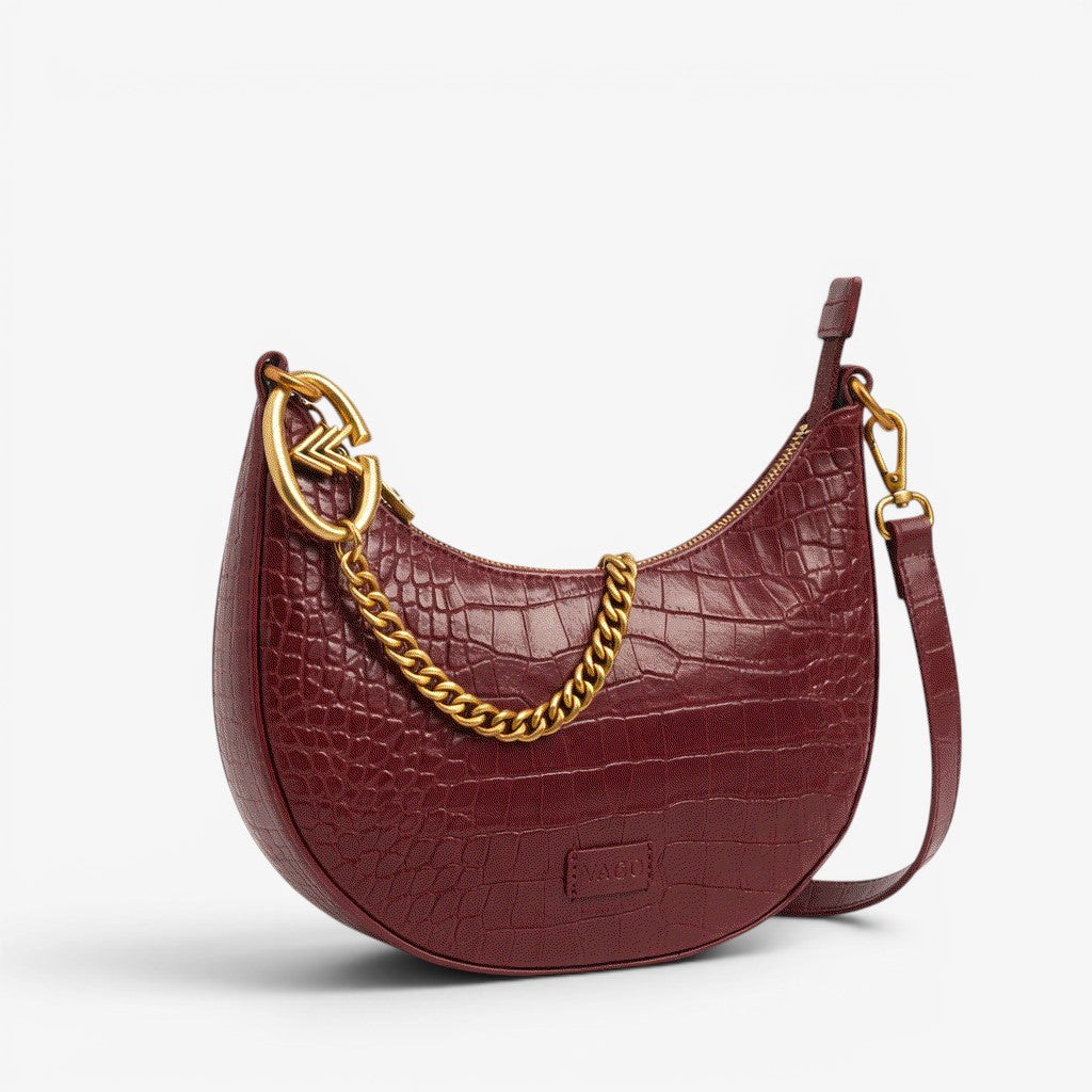 Maroon handbag with gold chain detail on a white background