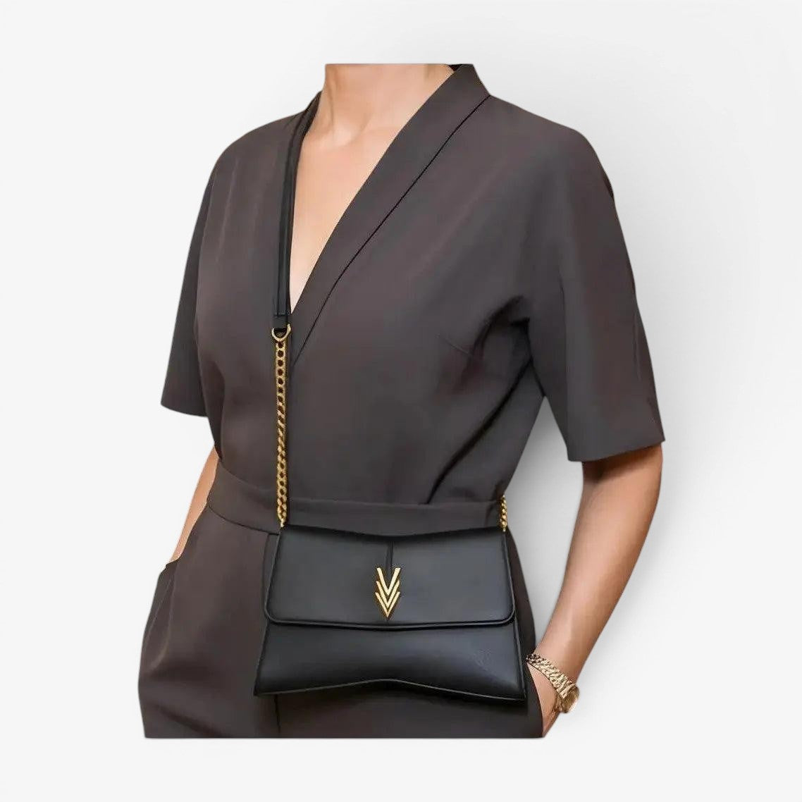 Person wearing a dark gray outfit with a black handbag featuring a gold chain strap.