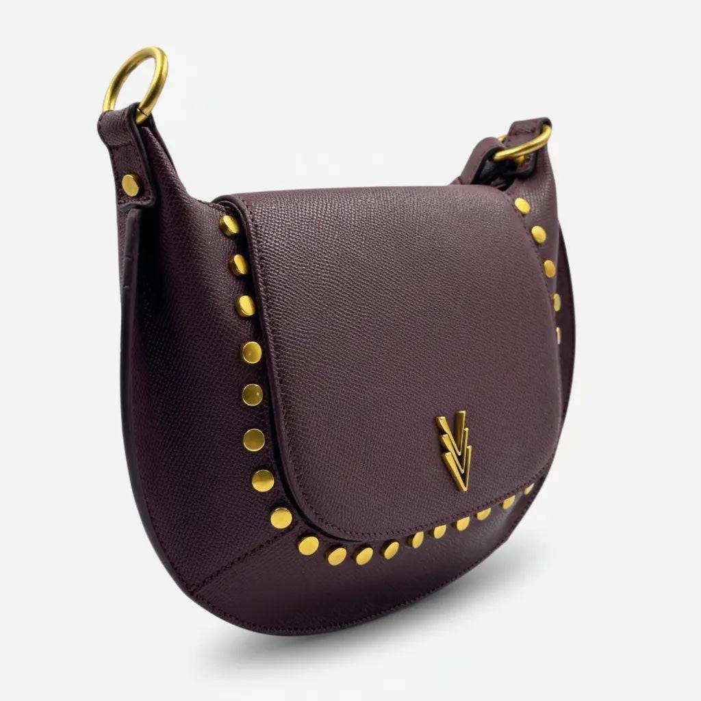 Purple handbag with gold studs and a brand logo on a light gray background