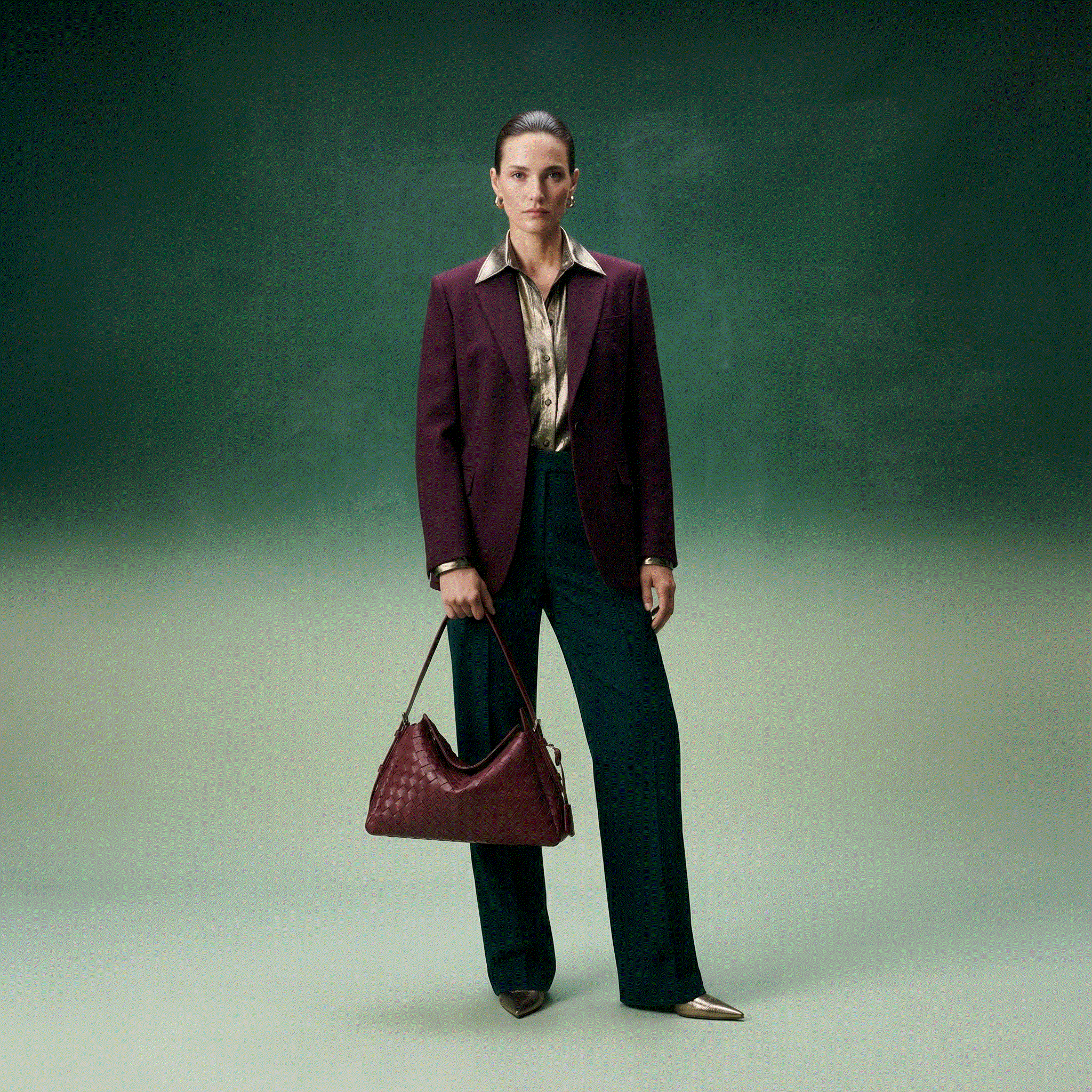 Woman in a suit holding a matching handbag against a gradient background