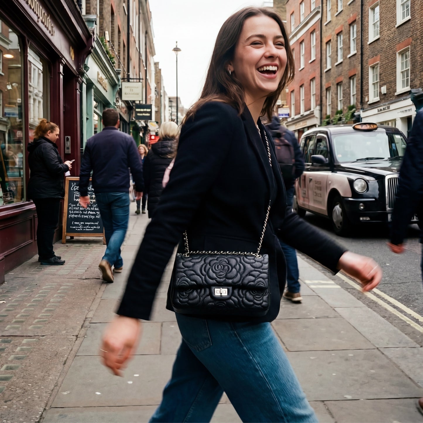 Woman walking on a city street with a black Chanel handbag