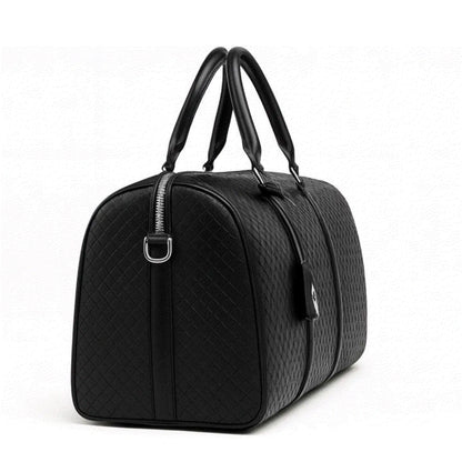 Black quilted duffel bag on a white background