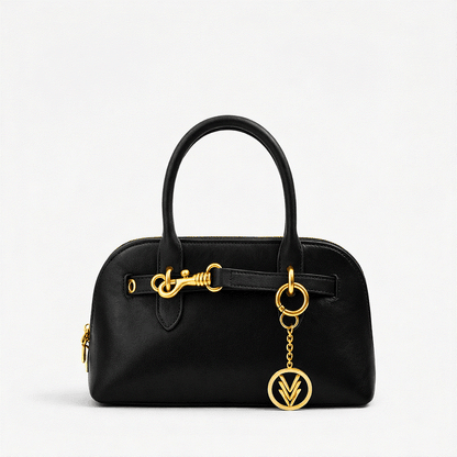 Black handbag with gold accents on a light gray background
