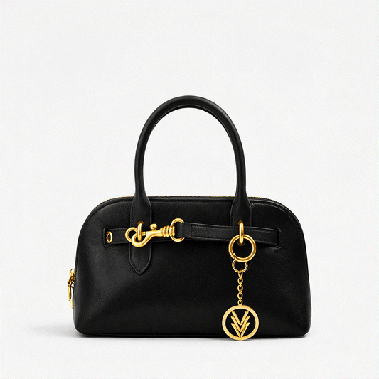 Black handbag with gold accents on a light gray background
