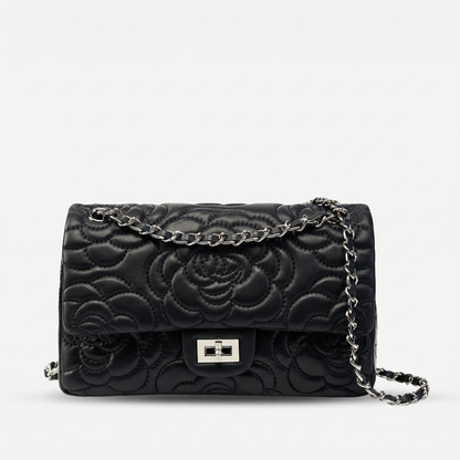 Black floral embossed handbag with a chain strap on a white background