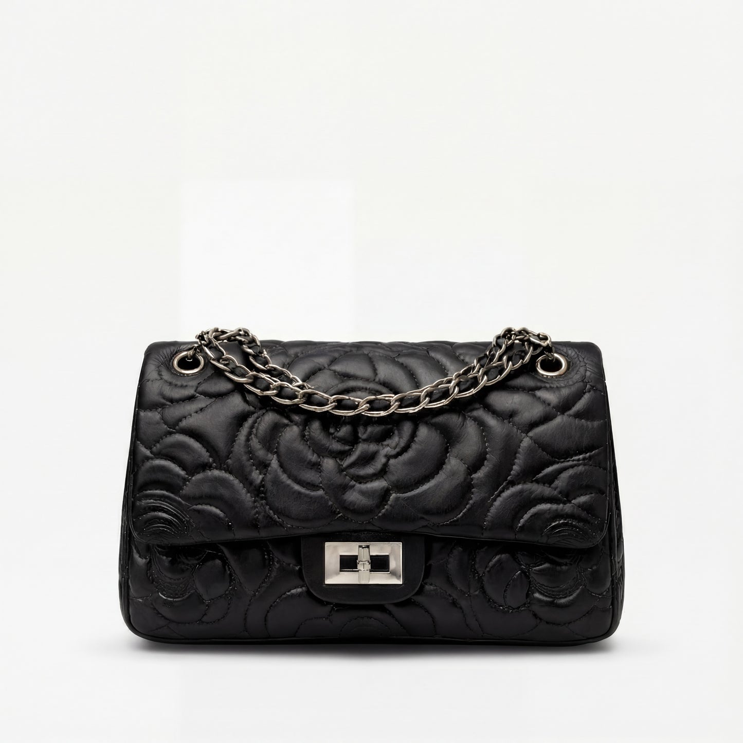 Black quilted handbag with a chain strap on a white background