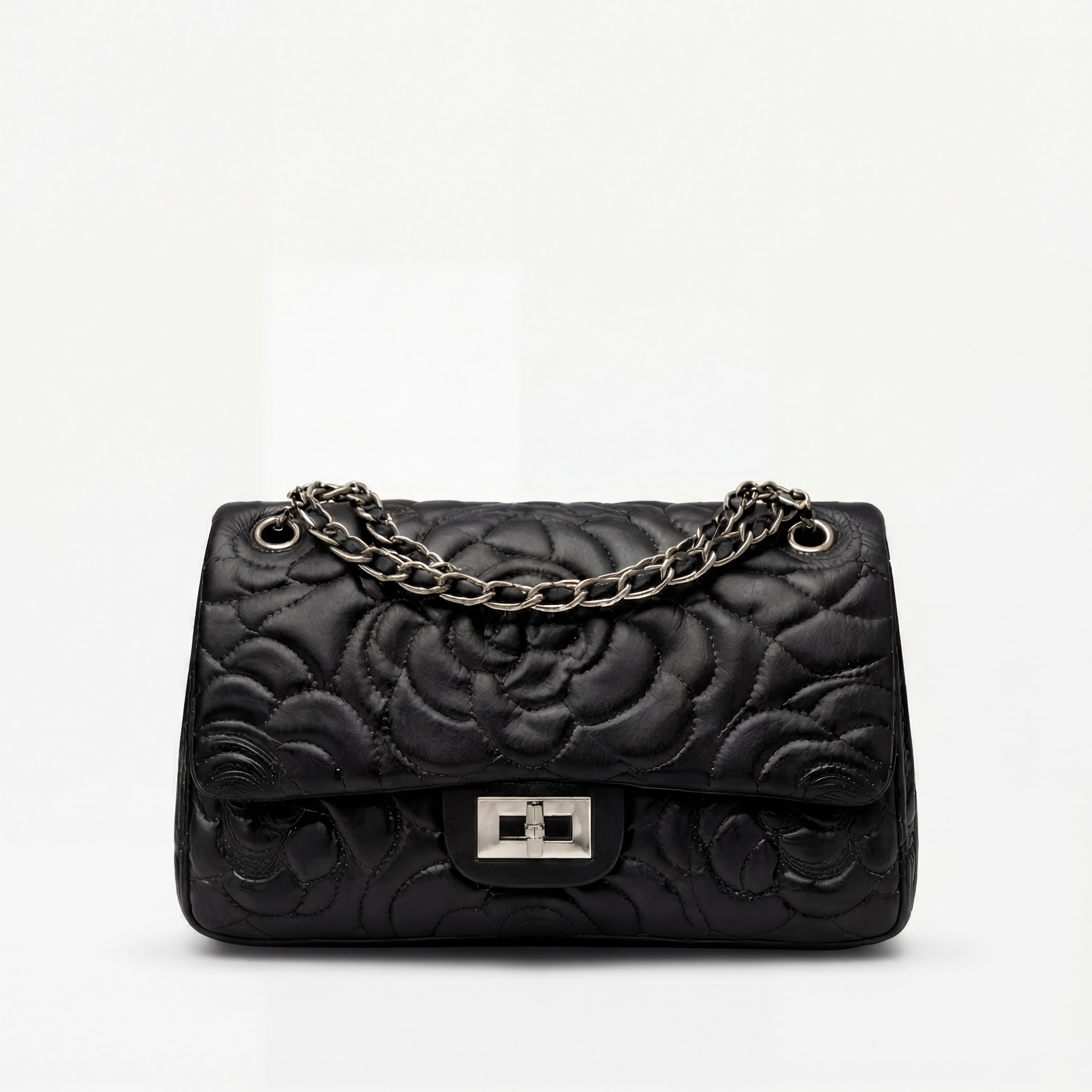 Black quilted handbag with a chain strap on a white background