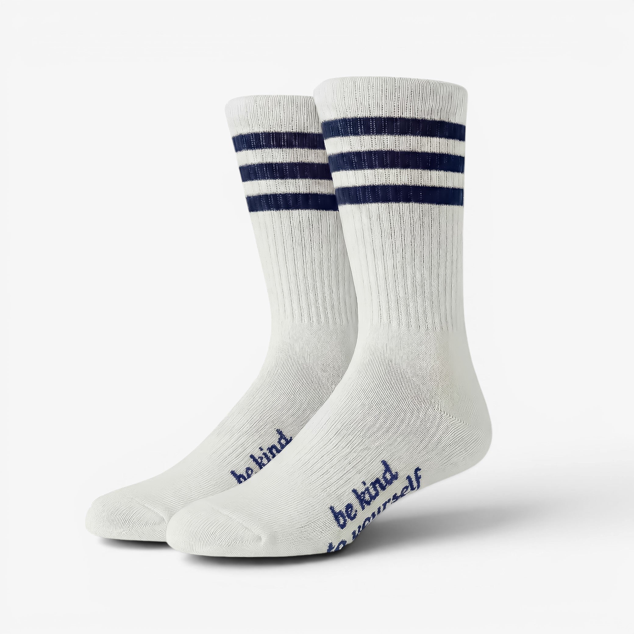 White socks with blue stripes and 'be kind' text on a white background