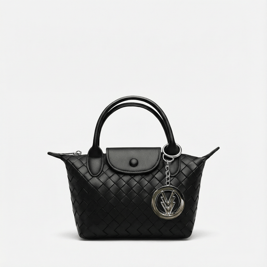 Black quilted handbag with a chain detail on a light gray background