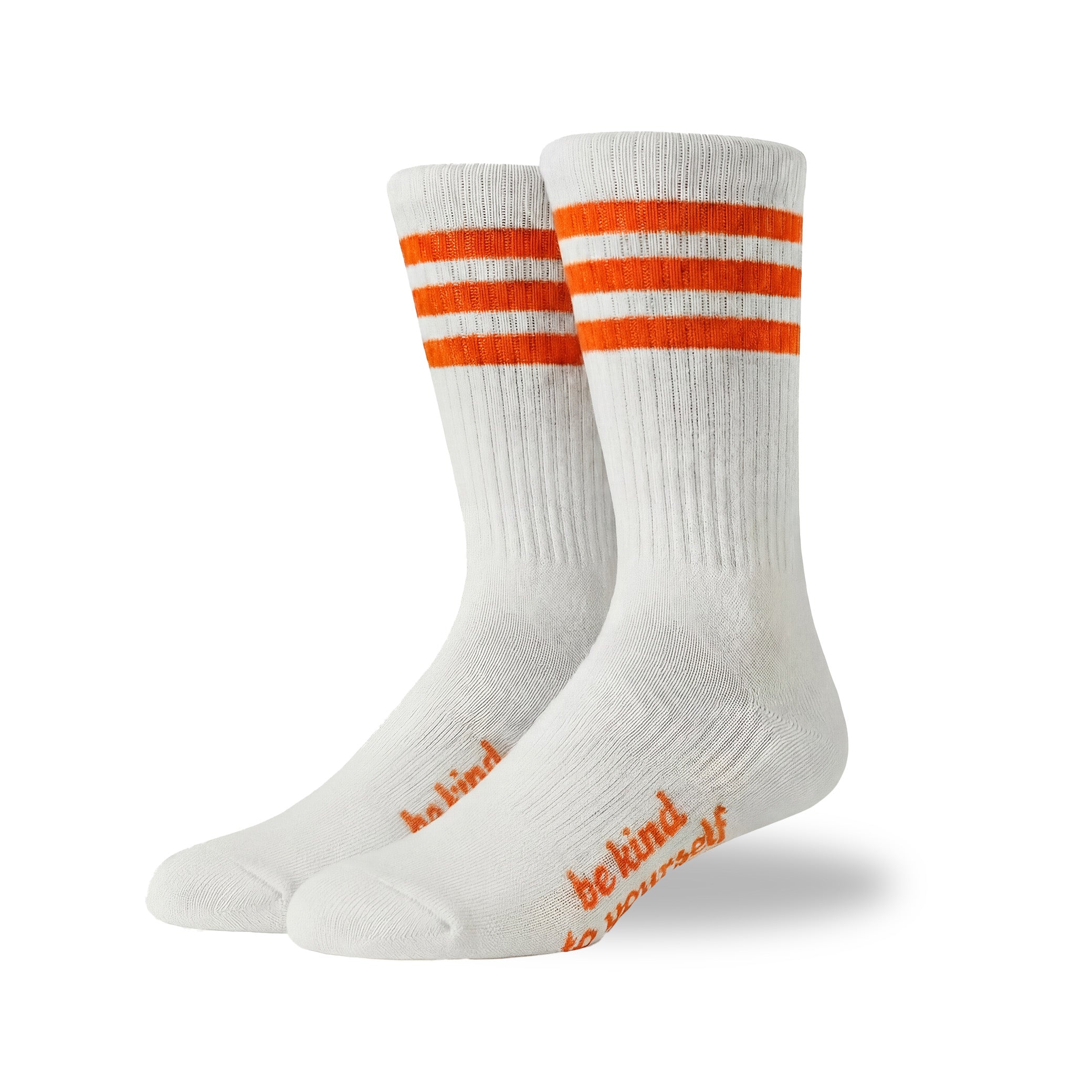White socks with orange stripes and 'be kind' text on a white background
