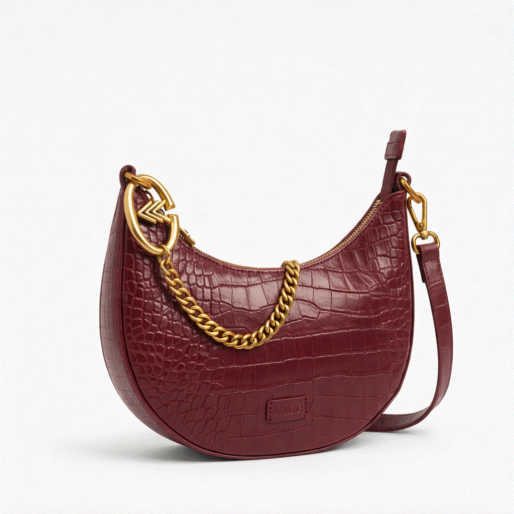 Maroon handbag with gold chain detail on a white background