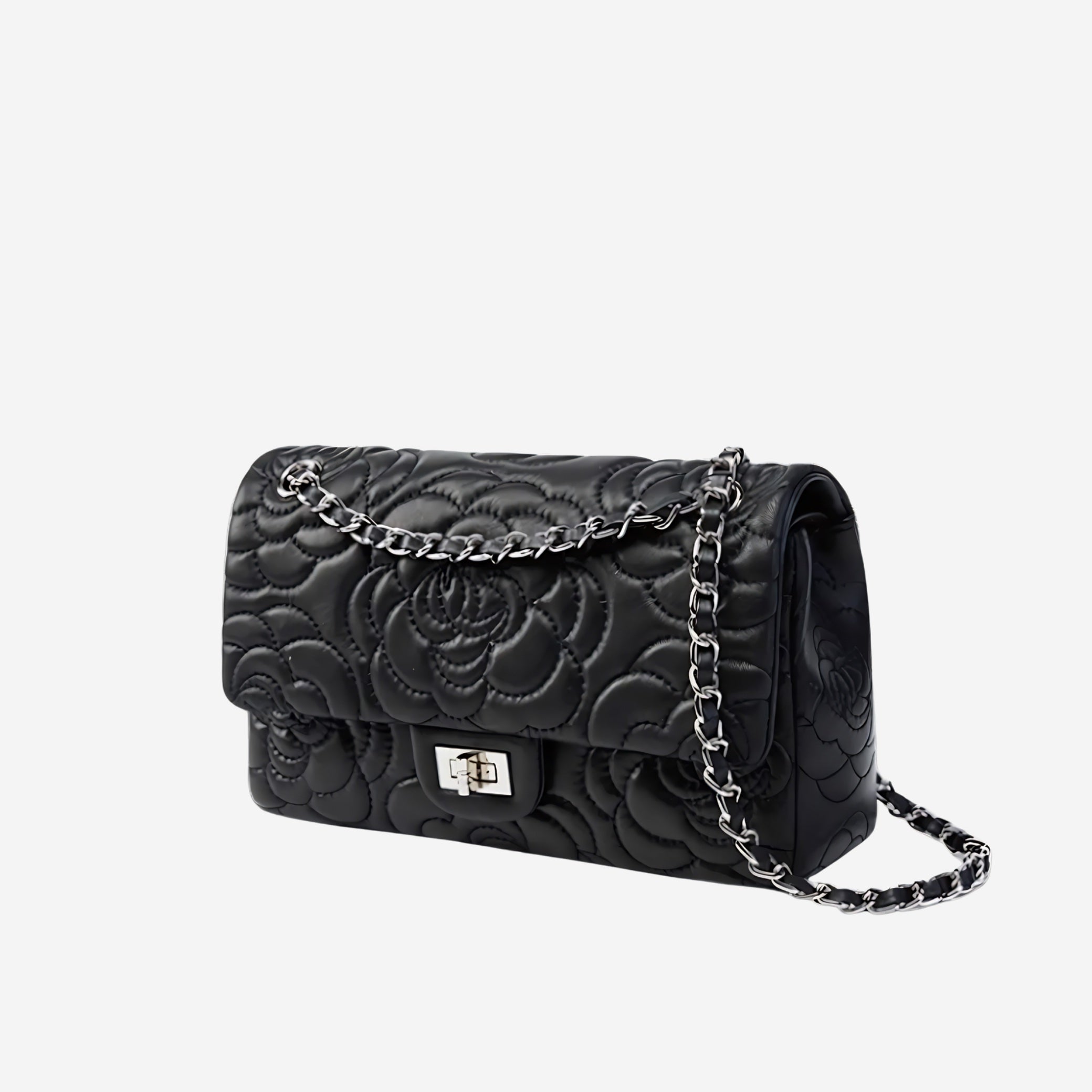Black quilted handbag with chain strap on a light gray background