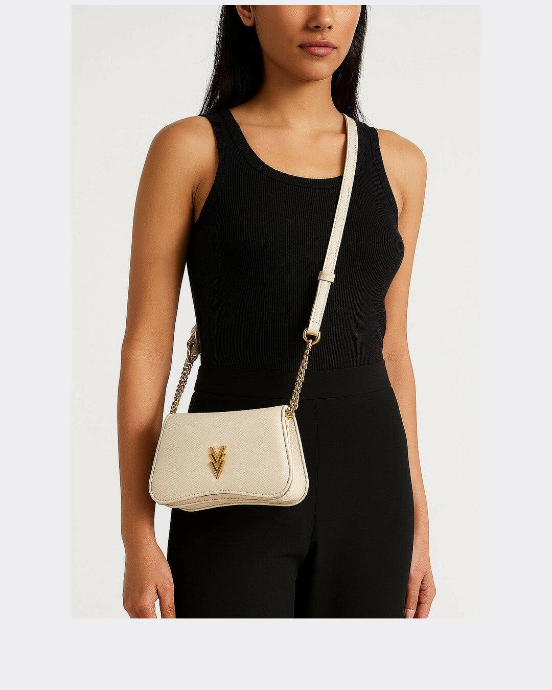 Woman wearing a black outfit with a beige handbag on a white background