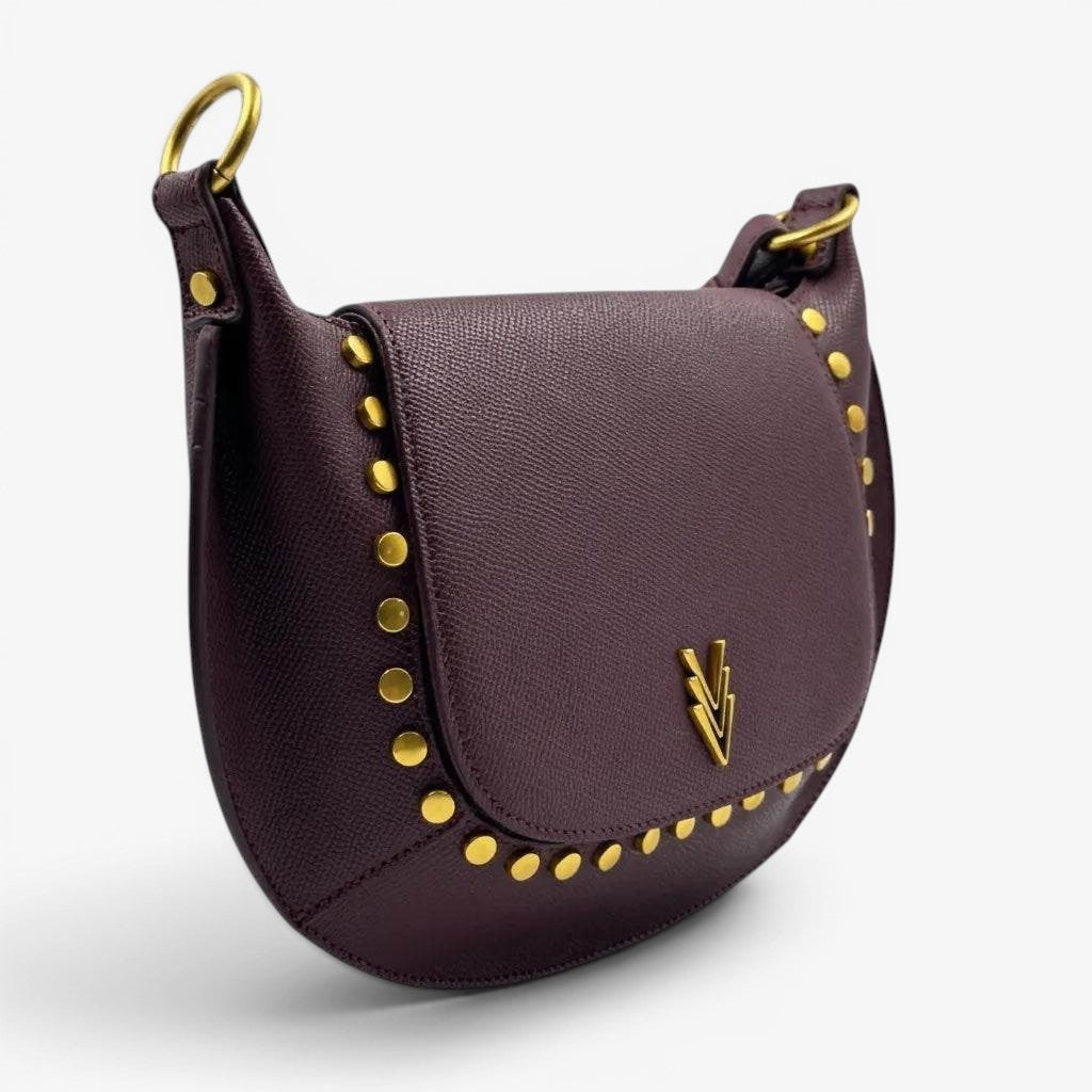 Purple handbag with gold studs and a brand logo on a light gray background