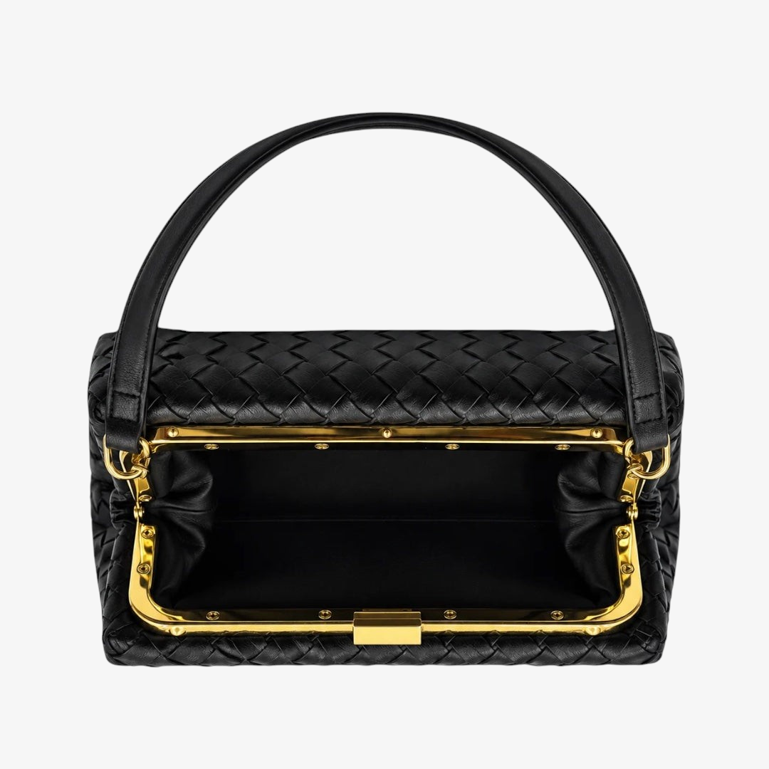 A black woven leather handbag with a structured rectangular shape, a single top handle, and prominent gold-tone metal frame detailing around the opening, shown against a plain white background.