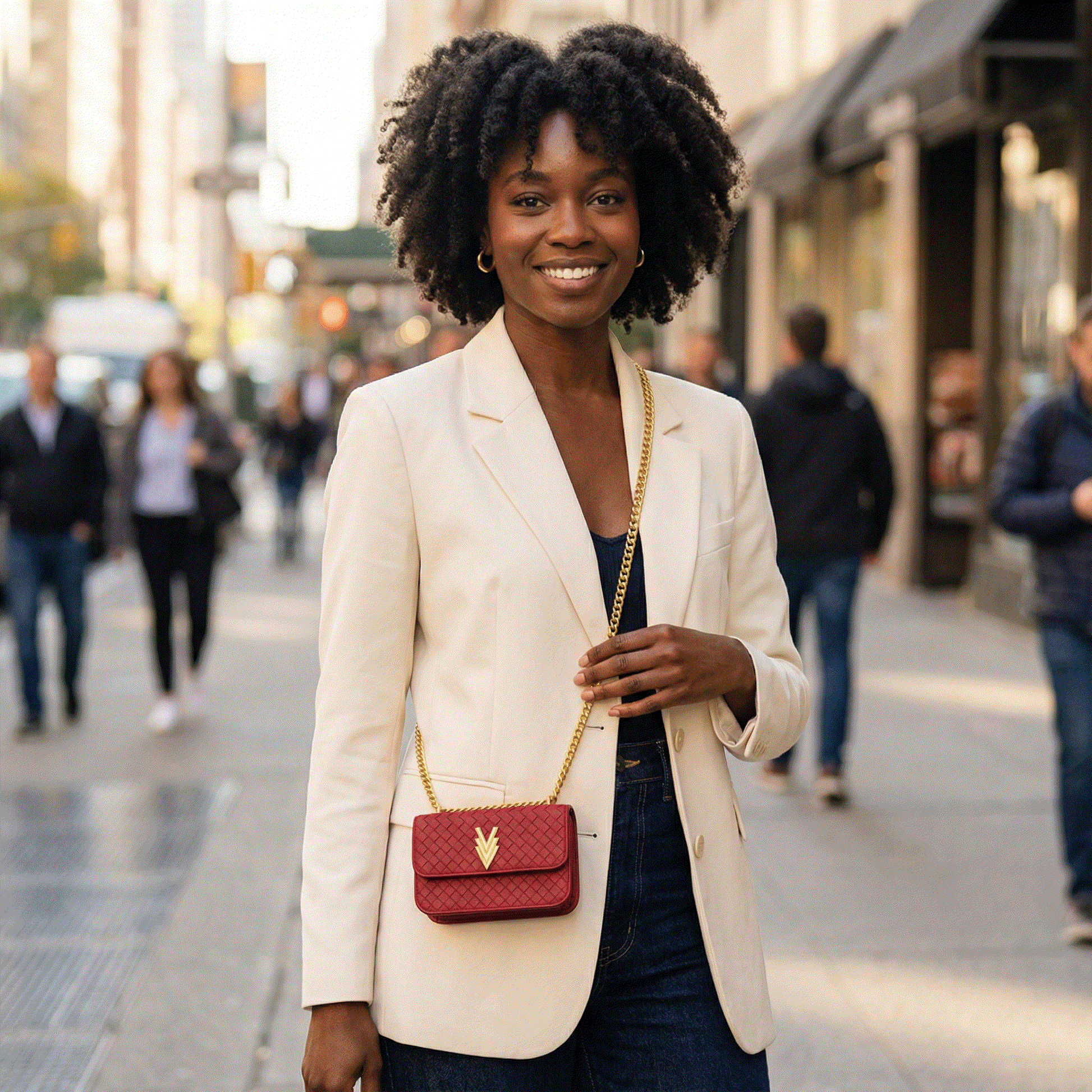 Woman in a beige blazer with a red handbag on a city street