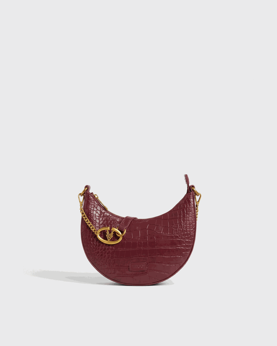 Maroon handbag with gold chain and clasp on a light gray background