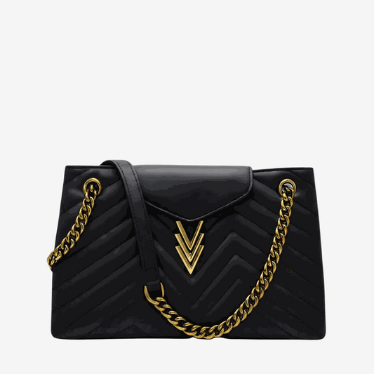 Black handbag with gold chain strap on a white background