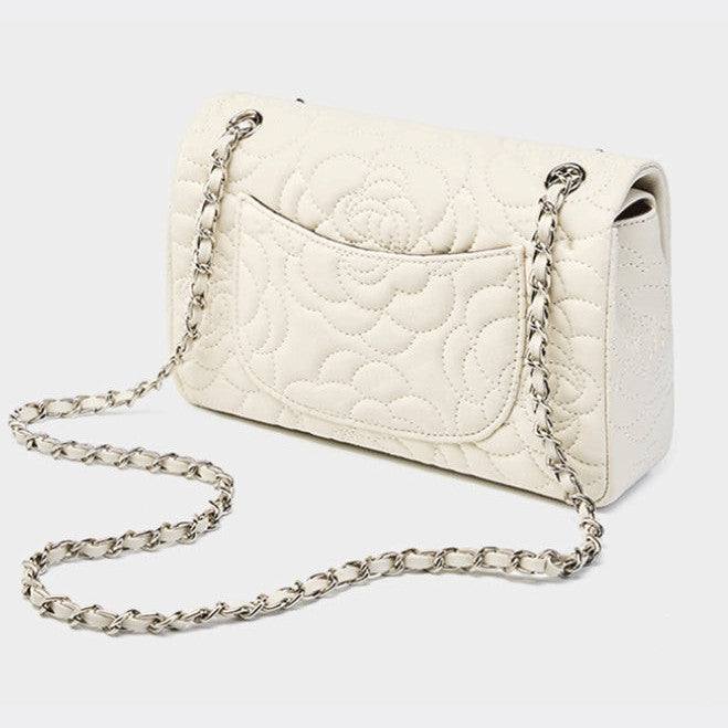White quilted handbag with a chain strap on a light gray background